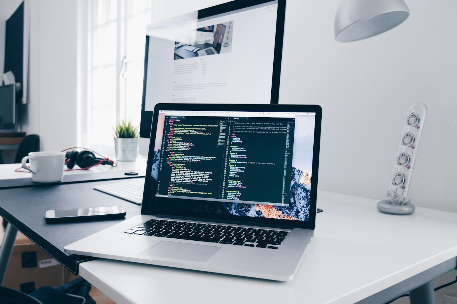 Laptop and monitor in a web development workspace
